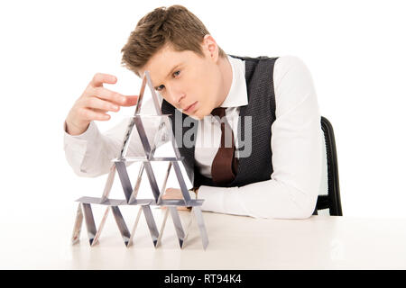 handsome man making pyramid from playing cards isolated on white Stock Photo