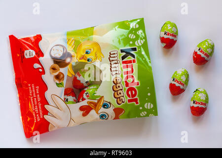 packet of Kinder mini eggs opened with contents spilled spilt isolated on white - fine milk chocolate covered mini eggs with a milky hazelnut centre Stock Photo