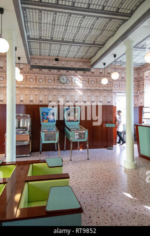 Pinball machines, juke box and pastel furniture at Bar Luce, Wes Anderson-inspired bar and cafe in the Fondazione Prada district of Milan, Italy Stock Photo
