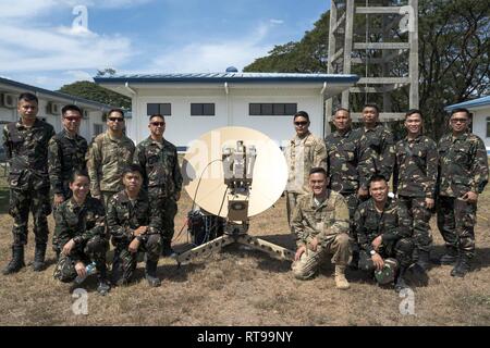U.S. Air Force communication personnel from the Pacific Air Forces (PACAF) Directorate of Air and Cyberspace Operations and the 291st Combat Communications Squadron pose alongside communication personnel from the Philippine Air Force 950th Communications, Electronics and Information Systems Group upon completion of a subject matter expert exchange during Bilateral Air Contingent Exchange-Philippines (BACE-P) at Cesar Basa Air Base, Philippines, January 30, 2019. The exchange included a demonstration of how to operate and install a satellite terminal as well as how to extend network services fr Stock Photo