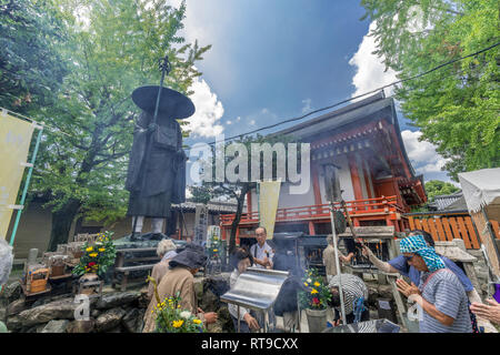 Kyoto, Japan - August 21, 2017 : Visitors pay their respects burning Incese sticks at the Jokoro and bronze statue of the legendary monk Kukai (Kobo D Stock Photo