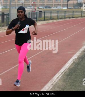 U.S. Army Sgt. 1st Class Carmen Granville races towards the finish line of the Camp Arifjan Half Marathon event on January 27, 2019 at Camp Arifjan, Kuwait. Stock Photo