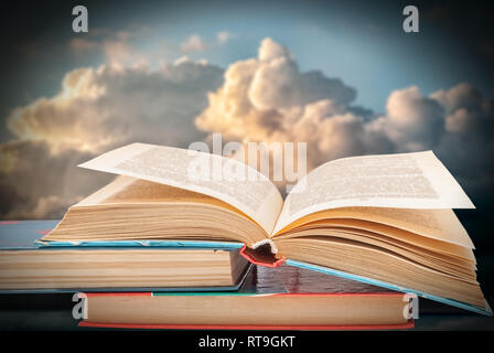 books on a background of blue sky with clouds at sunset Stock Photo