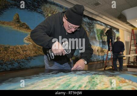 Volunteers from the Strategic Air Command Museum remove a 40-foot mural from the Global Lounge Jan. 29, 2019, at Offutt Air Force Base, Nebraska. Stock Photo