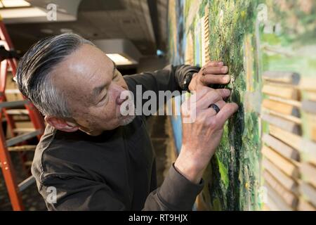 A volunteer from the Strategic Air Command Museum removes a 40-foot mural from the Global Lounge Jan. 29, 2019, at Offutt Air Force Base, Nebraska. The mural was installed in the, the, officer’s club in the 1960s. Stock Photo