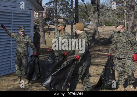 U.S. Marines and Sailors with II Marine Expeditionary Force pick up trash at Camp Lejeune, N.C., Jan. 31, 2019. The Marines and Sailors volunteered their time to create a cleaner environment for service members and their families, while contributing to make their base debris-free. Stock Photo