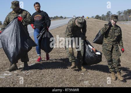 U.S. Marines and Sailors with II Marine Expeditionary Force pick up trash at Camp Lejeune, N.C., Jan. 31, 2019. The Marines and Sailors volunteered their time to create a cleaner environment for service members and their families, while contributing to make their base debris-free. Stock Photo