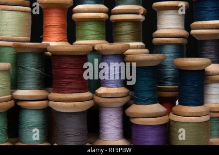 wooden coils with colorful threads of pastel colors Stock Photo