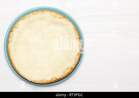 Whole cheesecake on a wooden white table. Top view. Copy space Stock Photo