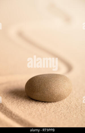 spa wellness relaxation stone. Concept for harmony spirituality and mental health. Japanese zen meditation garden with rock in raked sand. Stock Photo