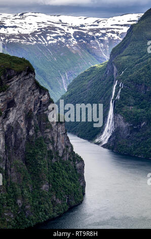 View of the Geirangerfjord with the Seven Sisters Waterfall from Ornesvingen. The fjord is one of Norway's most visited tourist sites. Stock Photo