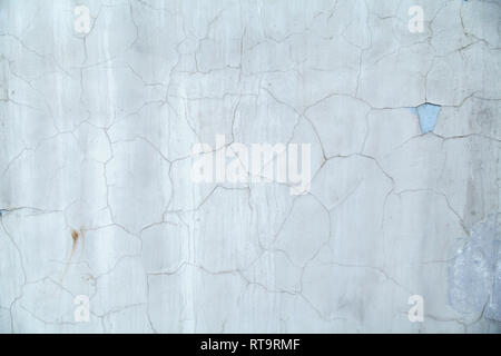 Gray-blue concrete wall is covered with cracked plaster. Cracks on the wall resemble a map of the world with the borders of States. Stock Photo