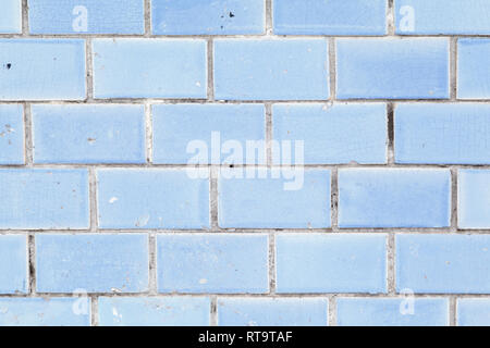 Blue background old ceramic tiles. Fourhorizontal rows of old small rectangular ceramic tiles of a beautiful sky blue color with covered with many sma Stock Photo