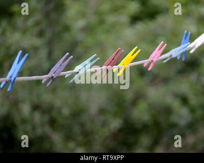 Clothespins on rope. Colorful clothes pegs on a rope Stock Photo