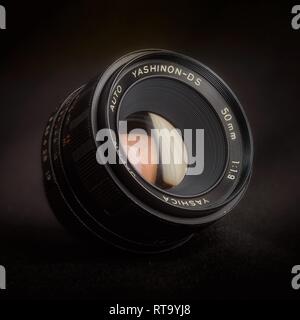 Essex, UK - 2/28/2019 : Yashica Auto Yashinon 50mm lens with an M42 mount against a dark background. Stock Photo