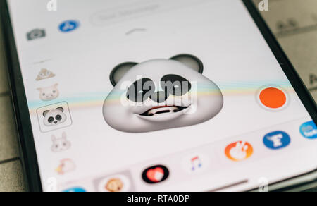 PARIS, FRANCE - NOV 9 2017: Panda bear 3d animoji emoji generated by Face ID facial recognition system with smiling face emotion close-up of the new iphone X 10 Display - tilt-shift lens used  Stock Photo