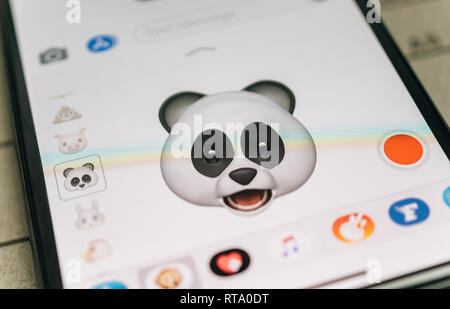 PARIS, FRANCE - NOV 9 2017: Panda bear 3d animoji emoji generated by Face ID facial recognition system with astonished face emotion close-up of the new iphone X 10 Display - tilt-shift lens used  Stock Photo