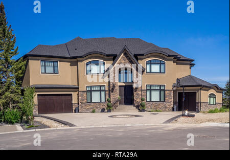 Luxury house at sunny day in Calgary, Canada. Taken from exterior on a sunny day. Each house has driveway and garage on the front of the house. Modern. Stock Photo