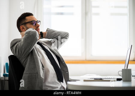 Young businessman is having pain in his neck and back. Stock Photo