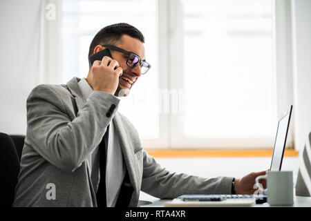 Young happy businessman is working in office. Stock Photo