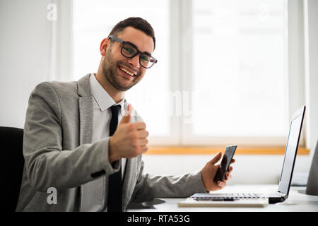 Young happy businessman is working in office. Stock Photo