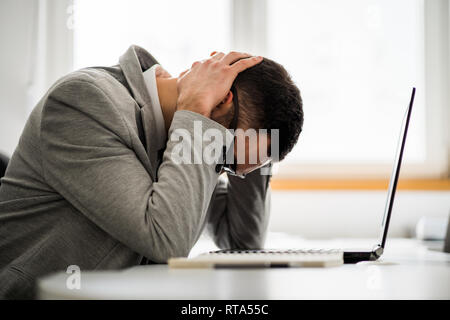 Young businessman is tired of overwork. He is depressed. Stock Photo