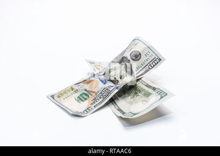 Crumpled American one hundred dollar banknotes in cross shape form on white background. Stock Photo