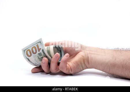 Rolled up hundred dollar banknotes in human hand on white background. Money is out of hand. Stock Photo