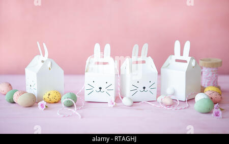 Little rabbit gift boxes with sweet easter eggs Stock Photo