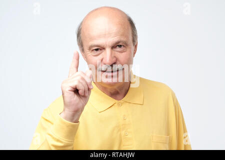 Strict mature man showing index fingers up, giving advice or recommendation Stock Photo