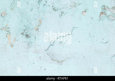 Textured background. Cracked concrete old wall. Light blue paint flakes on old rough concrete surface. Stock Photo