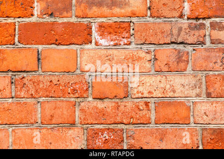 Old red brick uneven wall background. Close-Up of an Old Exterior Brick Wall, grunge background. Stock Photo