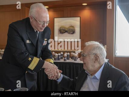 ST. LOUIS (Feb. 1, 2019) Retired Rear Adm. Lee Metcalf, left, presents Joseph Logan with a commemorative coin during Logan’s 98th birthday celebration at Thompson Coburn LLP law firm in St. Louis, Feb. 1, 2019. Logan is a World War II veteran and saw combat in both the European and Pacific theaters, supporting the Allied landings at Normandy on D-Day and earned the Bronze Star Medal for his actions during the Battle of Okinawa. Stock Photo