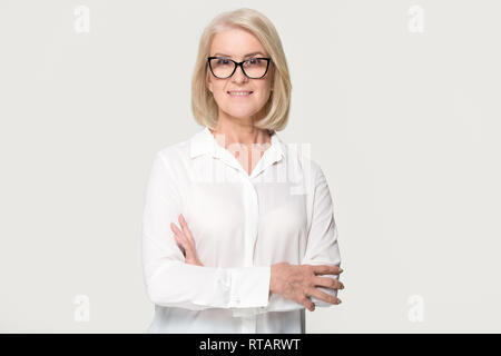 Mature businesswoman in glasses looking at camera isolated on background Stock Photo