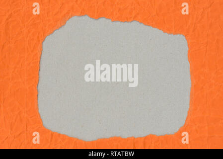 irregular shape  hole on piece on orange  color paper Stock Photo