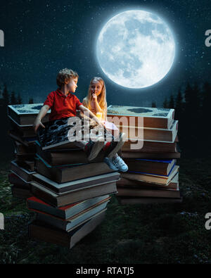 Little girl and boy sitting on the tower made of big books. Childhood dreams, creative and education concept. Wondering world. abstract collage Stock Photo