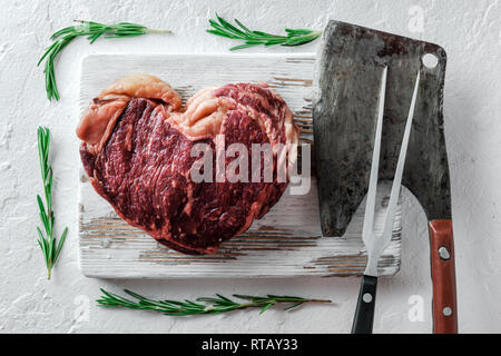Heart shape marbling ribeye steak on white plate. Prime rib beef chop Stock Photo