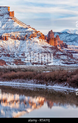 Snow from a recent storm  line the banks of the Colorado and the mesas and mountains surrounding Fisher Towers near Moab, Utah. Stock Photo