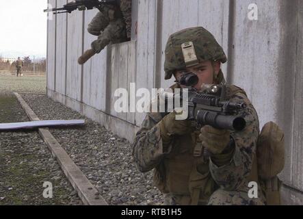 Cpl. Joshua Polk, a team leader with Charlie Company, Battalion Landing Team, 1st Battalion, 4th Marines, provides security while his fellow Marines exit the compound during Military Operations in Urban Terrain training during Exercise Forest Light at Aibano Training Area, Kyoto, Japan, Feb. 5, 2019. Forest Light is a semi-annual exercise conducted by U.S. Marines and members of the Japan Self-Defense Force in order to strengthen interoperability and combined capabilities in defense of the U.S.-Japan alliance. The 31st MEU, the Marine Corps’ only continuously forward-deployed MEU partnering wi Stock Photo