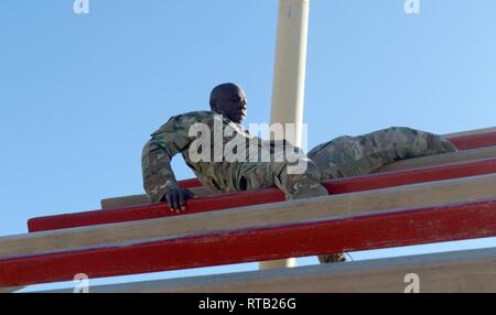 Sgt. Ruel Richards, 1st Theater Sustainment Command, completes the weaver during an obstacle course on Day Zero of Air Assault School at Camp Buehring, Kuwait, Feb. 5, 2019. Stock Photo