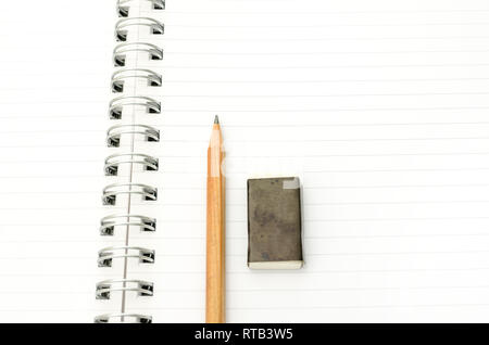Pencil and eraser lying on open spiral notebook. Empty space ready for your text. Stock Photo