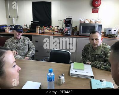 Maj. Gen. Flem B. “Donnie” Walker, commanding general of the 1st Theater Sustainment Command, Chief Warrant Officer 3 Terry Lee Senn, vessel master of the logistics support vessel USAV MG Charles P. Gross (LSV 5), Chief Warrant Officer 3 Derrick Swetnam, vessel master of the logistics support vessel USAV The SP4 James A. Loux (LSV 6), and Capt. Kristen Bell, commander of the 393d Transportation Detachment, discuss Army watercraft aboard LSV 5 while moored at the Kuwait Naval Base, Kuwait, Feb. 6, 2019. Stock Photo