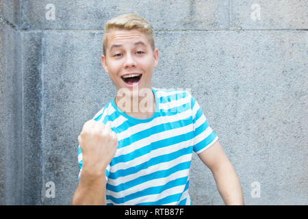 Successful german young adult man with colored blond hair outdoor in the summer with copy space Stock Photo