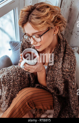 Positive nice woman enjoying her delicious coffee Stock Photo