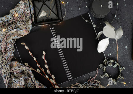 Opened notebook with black sheets on dark background. Top view. Stock Photo