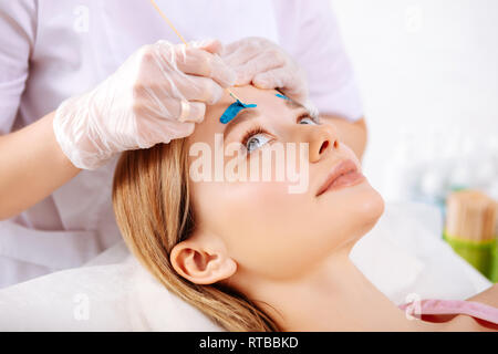 Client feeling concerned having eyebrows depilation for first time Stock Photo