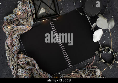 Opened notebook with black sheets on dark background. Top view. Stock Photo