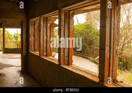 The inside of an abandoned run down mansion outside the town of Kampot in Cambodia, the orange brick work is being weathered away Stock Photo