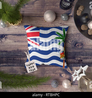 Happy New Year tag with British Indian Ocean Territory flag on pillow. Christmas decoration concept on wooden table with lovely objects. Stock Photo