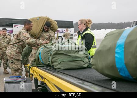 HANSCOM AIR FORCE BASE, Mass. - Members of C Company 1-181st Infantry Regiment, Massachusetts National Guard load baggage prior onto the plane that will take them to the first stop of their deployment. Stock Photo